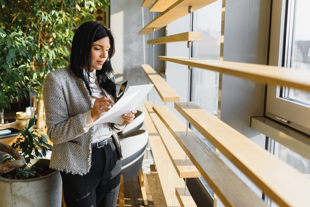 Mujer leyendo un papel frente a la venta de la oficina de home ibiza asesoramiento inmobiliario